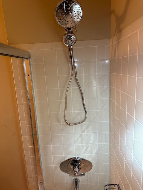A newly fitted chrome shower valve and hand shower on a tiled bathroom wall