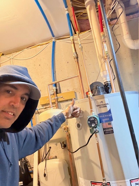 David beside a newly installed Bradford White water heater with a recirculating pump on the copper hot line